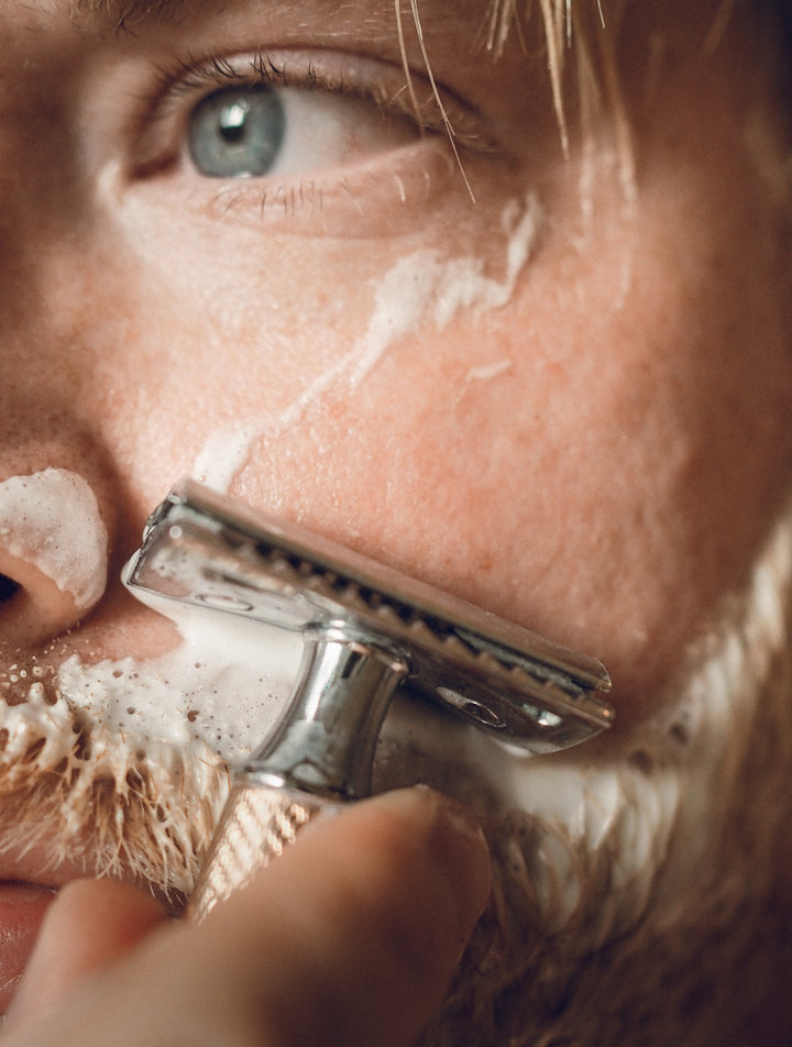 man shaving with a safety razor