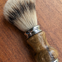 Silvertip badger shave brush with black limba handle on a slab of mesquite