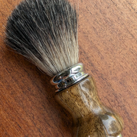 black badger shave brush with black limba handle on a slab of mesquite