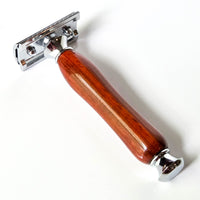 Shaving razor with a wooden handle made from african padauk on a white background