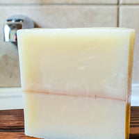 Sandalwood shampoo bar for men on the bath tub. The best bar soap for hair, face and body.