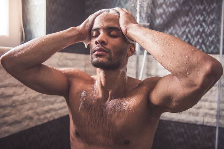 man taking a shower with grooming products