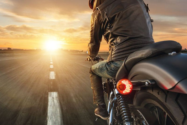 man on motorcycle following the road less travelled