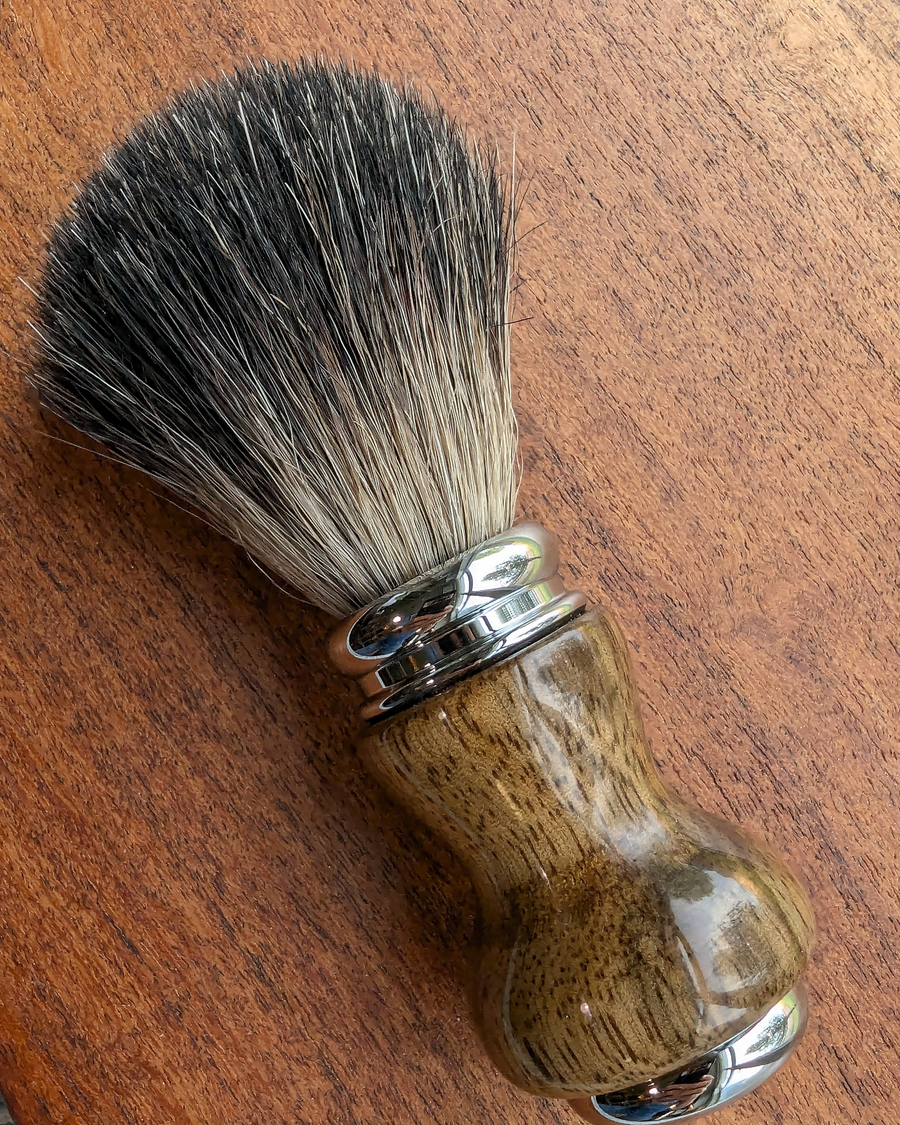 black badger shave brush with black limba handle on a slab of mesquite
