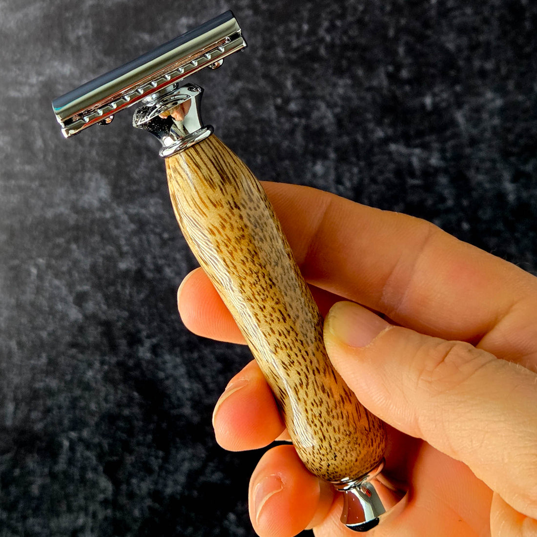 luxury wooden razor handle close up texture held in a hand
