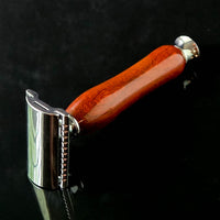 Shaving razor with a traditional wooden handle made from padauk on a black background