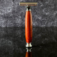 Shaving razor with a modern wooden handle made from padauk on a dark gray background