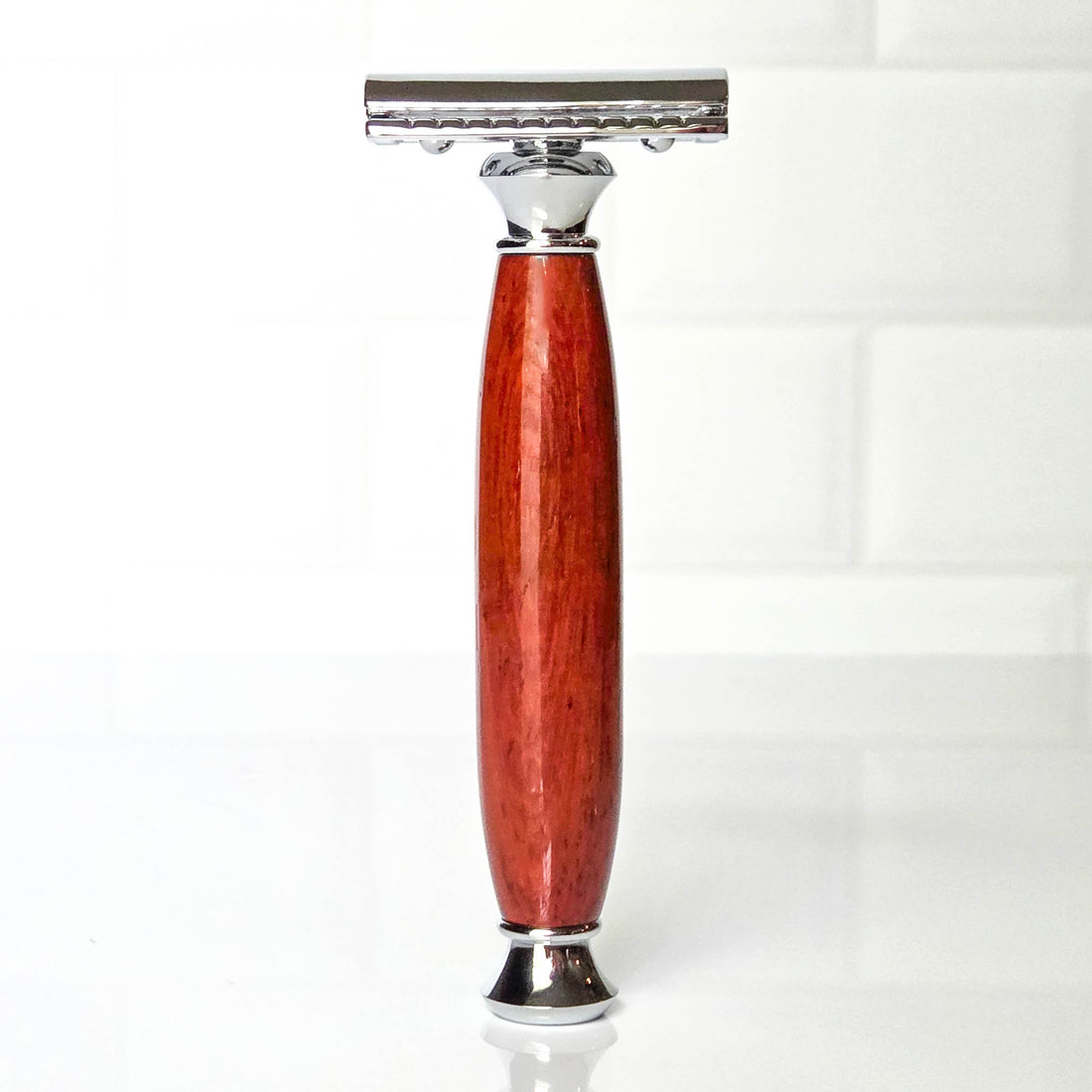 Safety razor with a modern handle made from padauk on a white background