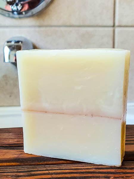 Sandalwood shampoo bar for men on the bath tub. The best bar soap for hair, face and body.